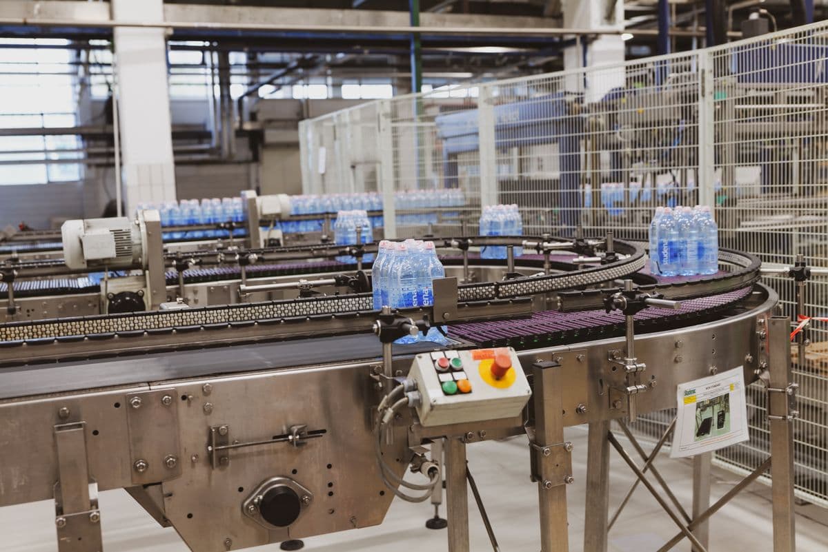 Packaged water bottles moving along a conveyor on a filling line