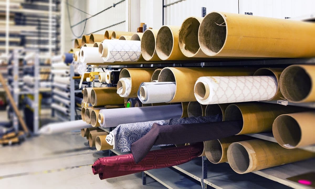 Rolls of fabric stacked on racks in a textile factory